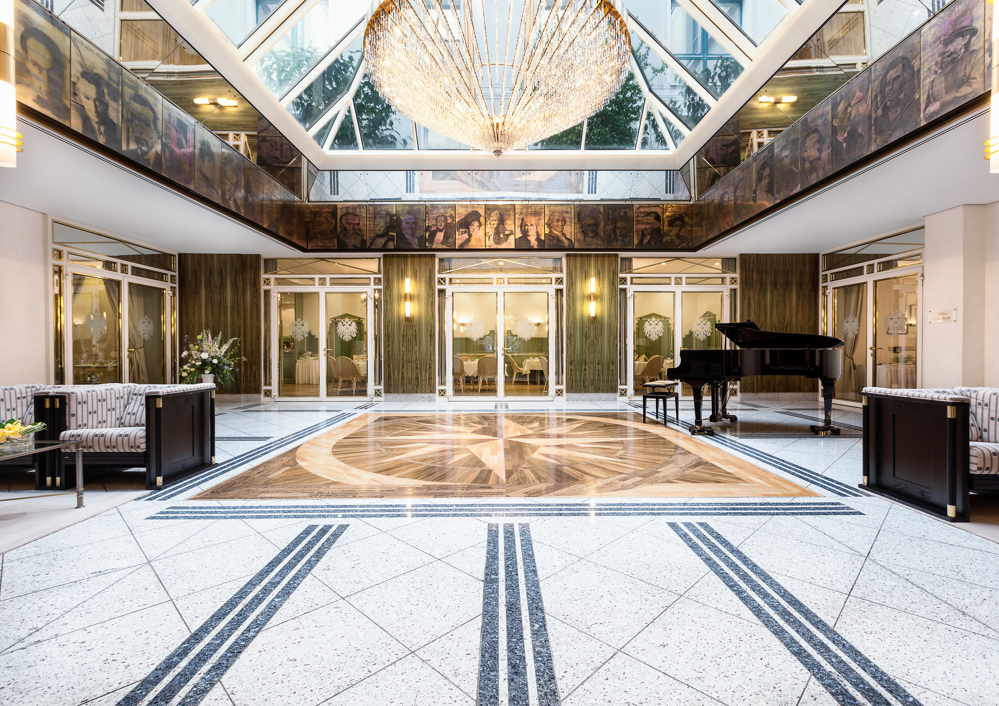 Elegante Hotellobby im Russischen Hof Weimar mit Glasdecke, Kronleuchter, Marmorboden und schwarzem Flügel